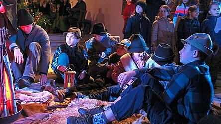 Hirtenkinder lagern um das Feuer. Der Grundschulchor und im Hintergrund die Familie Franz geh&ouml;rten ebenso zu den Mitwirkenden.