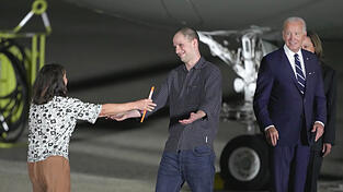 Endlich in Freiheit: Der Reporter Evan Gershkovich (M.) umarmt seine Mutter Ella Milman, w&auml;hrend US-Pr&auml;sident Joe Biden (r.) zuschaut auf dem Luftwaffenst&uuml;tzpunkt Andrews nach dessen Freilassung im Rahmen eines Gefangenenaustauschs. Russland und der Westen machen einen beispiellosen Gefangenen-Deal.