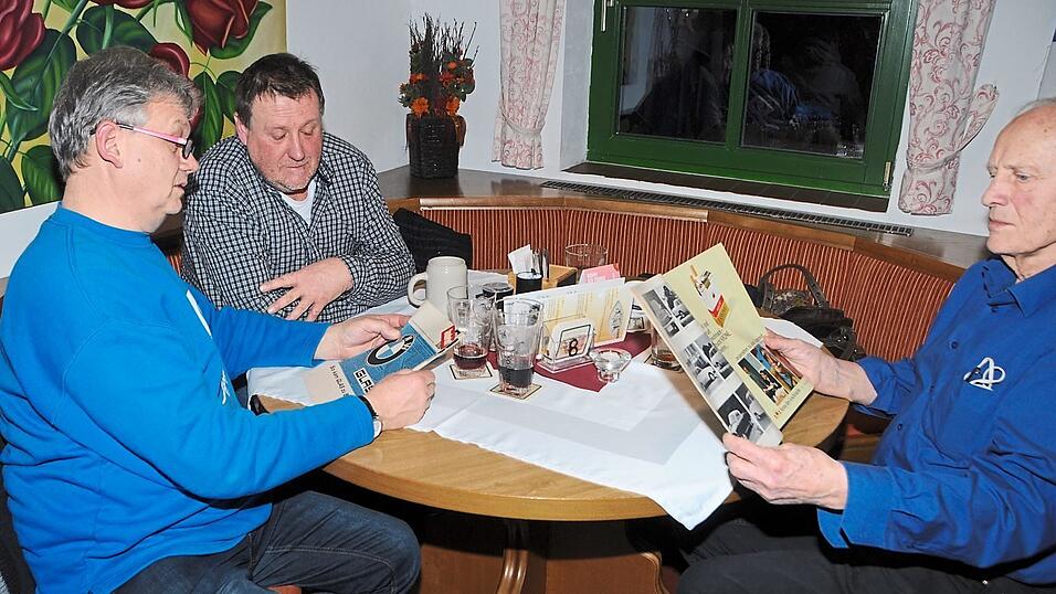 Der Vorstand der Goggo-und Glasfahrergemeinschaft Bert F&uuml;chsl (links) besitzt ein altes Heft, das den Zusammenschluss der Firmen Glas und BMW dokumentiert.