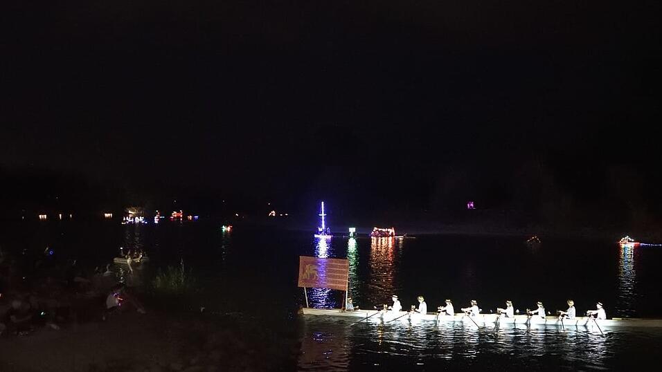 Bunt beleuchtete Boote fahren bei der Lampionfahrt über die Donau.