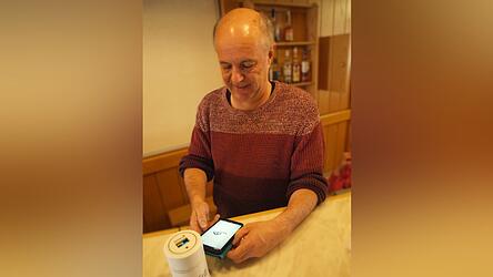 Joachim Dorner schiebt ein Radon-Messger&auml;t &uuml;ber den Bartresen. 78 Becquerel misst es. Eine App spuckt dazu einen Graphen aus.