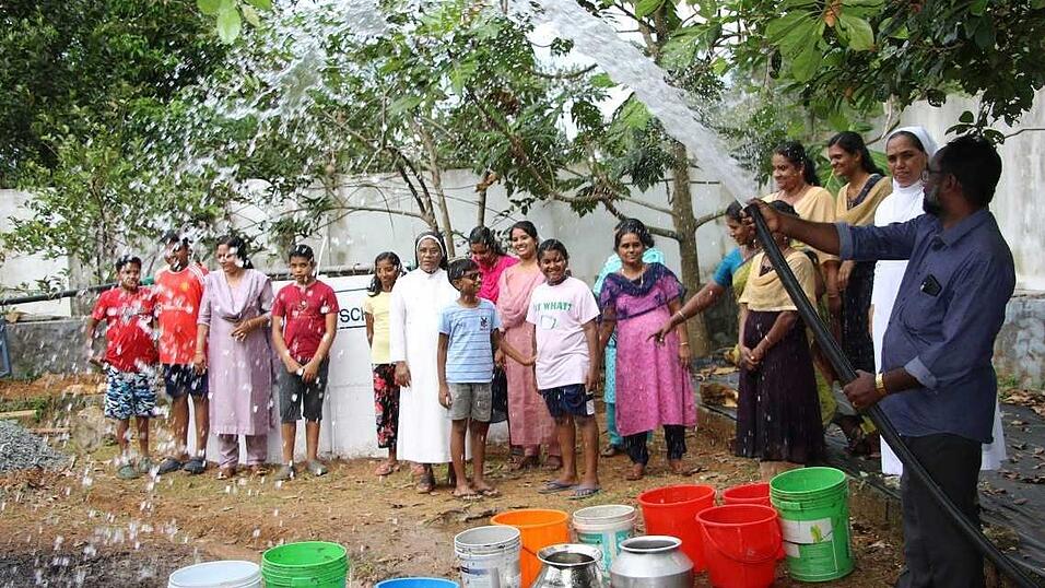 Die Menschen zeigen sich glücklich über die feierliche Übergabe eines Brunnens.