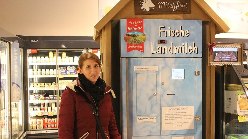 Lena Irrgang neben ihrem Automaten. Das die Milch aus dem Automaten gut angenommen wird, bestätigt auch Andreas Bortar, der Geschäftsführer des Rewe-Markts in Cham. Für ihn ist die Milch ein Alleinstellungsmerkmal. 'Ich verdiene an der Milch aus dem Automaten nicht so viel, wie an der Milch im Tetrapack', sagt Bortar. Vor allem junge Familien holen sich hier am Wochenende frische Milch.
