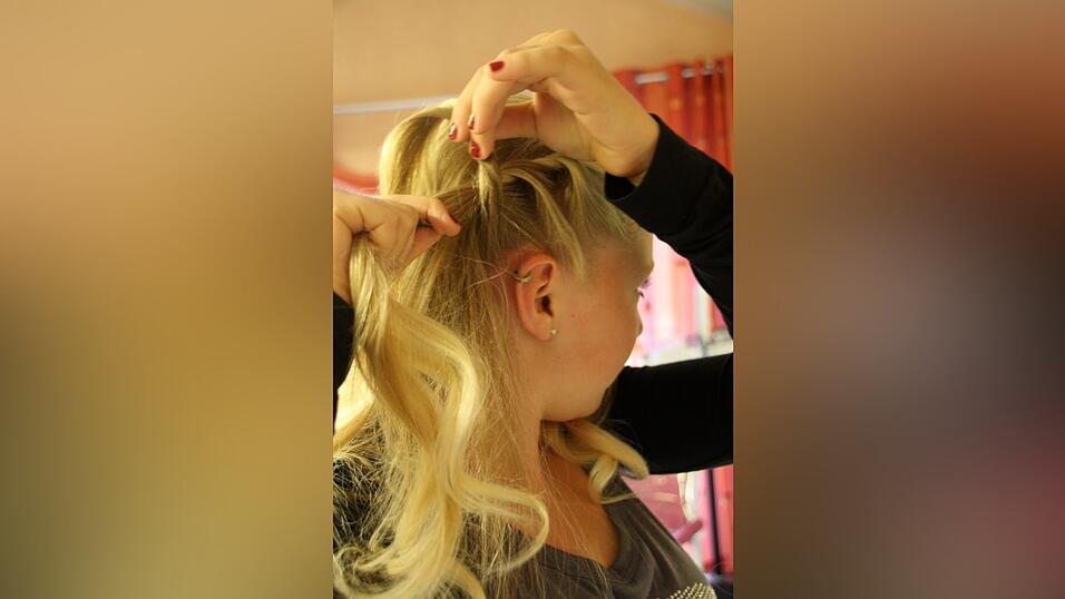 1. Zun&auml;chst toupiert Vanessa den Hinterkopf leicht an und zieht einen Seitenscheitel.