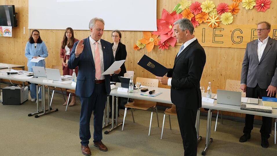 Helmut Plenk (l.) wird von Landrat Ronny Raith vereidigt. Seit 2020 ist er ester Stellvertreter.