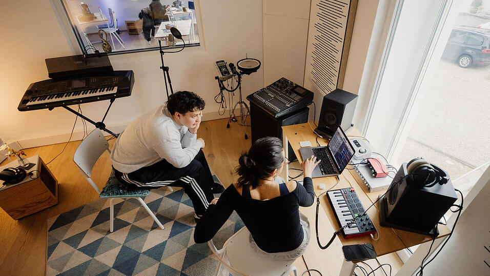 K&uuml;nstler Ez Kamil und die K&uuml;nstlerin elimako. Im Hintergrund, durch die Glasscheibe, ist die K&uuml;nstlerin BELLI zu erkennen.