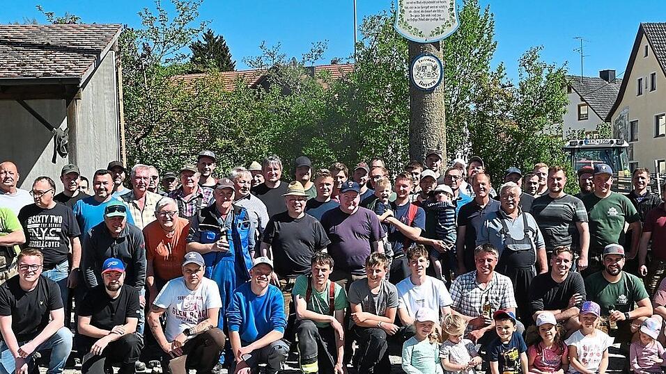 Gruppenfoto nach getaner Arbeit: In Aiglsbach hat das Maibaumaufstellen Tradition, wobei das ganze Dorf - Jung und Alt - mit anpackt.