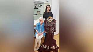Schneiderin Hanna Eichbichler hält das von Kerner genähte Kleid.