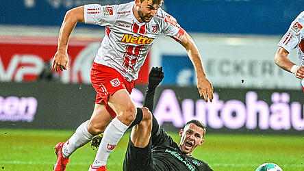 Den Rang ablaufen wollen am Freitag unter Flutlicht die Jahn-Spieler um Kapitän Benedikt Gimber (l.) dem Bundesliga-Absteiger SpVgg Greuther Fürth (Branimir Hrgota, am Boden).