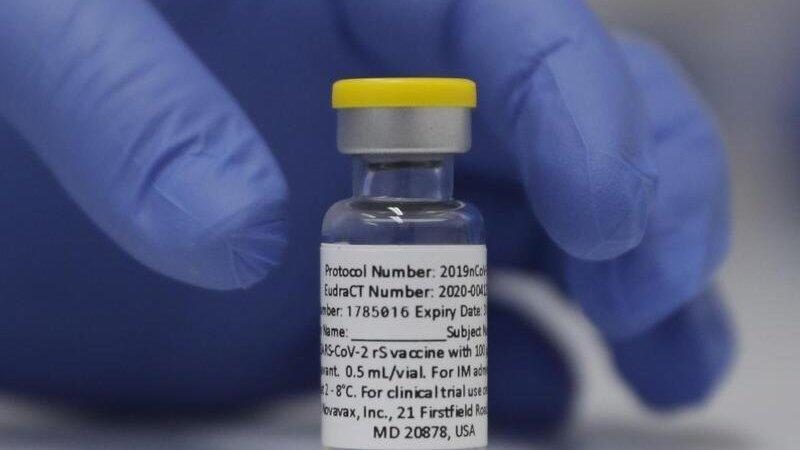 Eine Ampulle mit dem Corona-Impfstoff des US-Herstellers Novavax steht auf einem Tisch. Eine Ampulle mit dem Corona-Impfstoff des US-Herstellers Novavax steht auf einem Tisch.