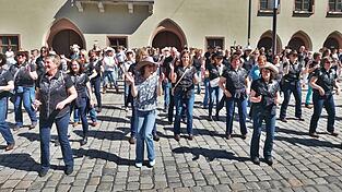 Gute Rhythmen bei bestem Wetter: Die Teilnehmer des Internationalen Linedance-Flashmob legten eine flotte Sohle auf den Asphalt.&nbsp;