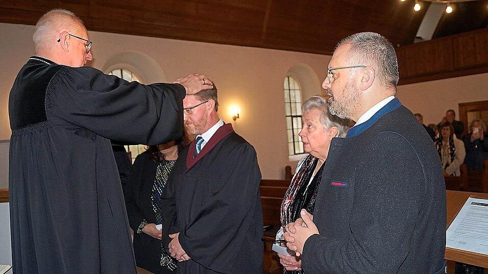 Durch Handauflegung &uuml;bertr&auml;gt Regionalbischof Klaus Stiegler im Beisein von Einsegnenden das Amt zum Pr&auml;dikanten.