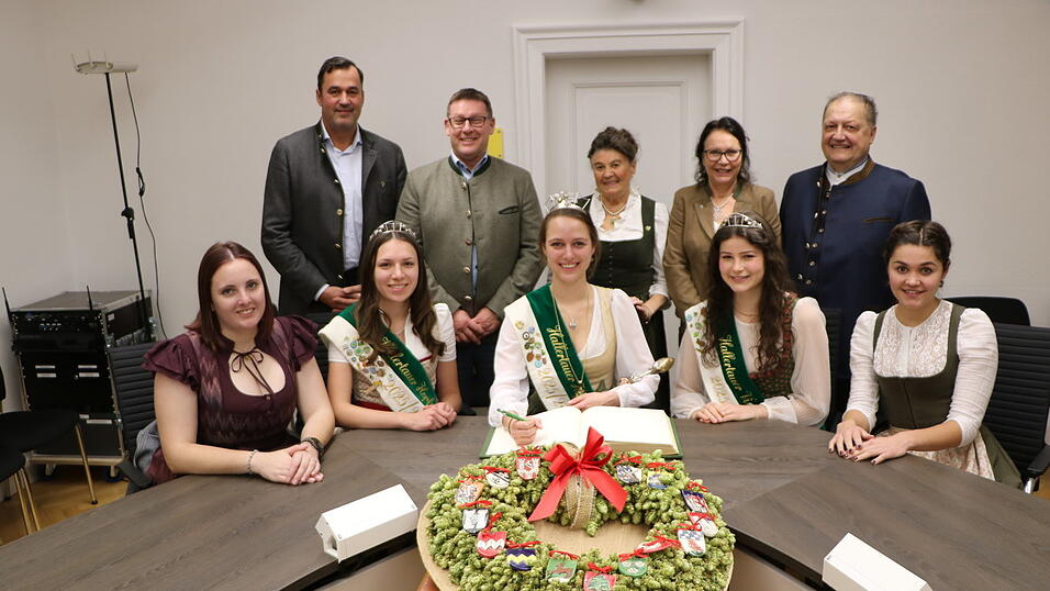 Ins Goldene Buch der Stadt haben sich die amtierenden Hallertauer Hopfenhoheiten flankiert von ihren Vorgängerinnen eingetragen. Bei dieser Gelegenheit wurde auch der frisch gebundene neue Hopfenkranz mit den Wappen der Hallertauer Siegelgemeinden für den Sitzungssaal übergeben.