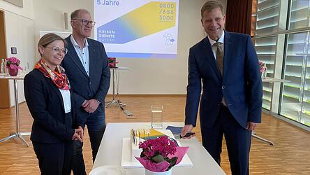 Beim Anschneiden der Jubil&auml;umstorte (v. l.): Helga Stierstorfer vom Bezirk Niederbayern, Werner Sagmeister, Leiter der Leitstelle des Krisendienstes, und Bezirkstagspr&auml;sident Olaf Heinrich