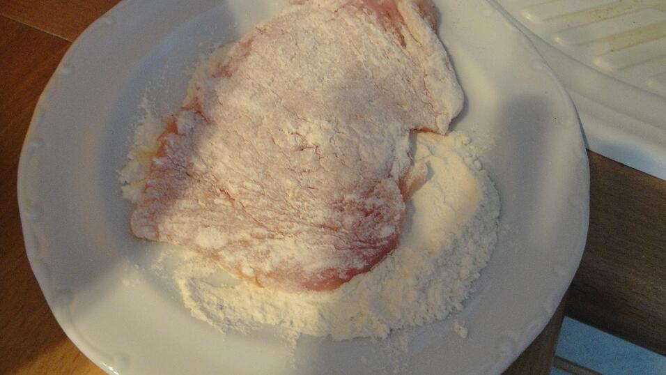 Die Schnitzel in Mehl wenden.