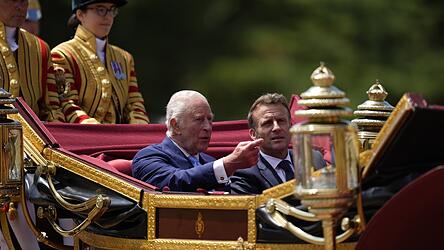 Der britische König Charles III. und Frankreichs Präsident Emmanuel Macron im Gespräch während der Kutschenprozession zum Schloss Windsor.