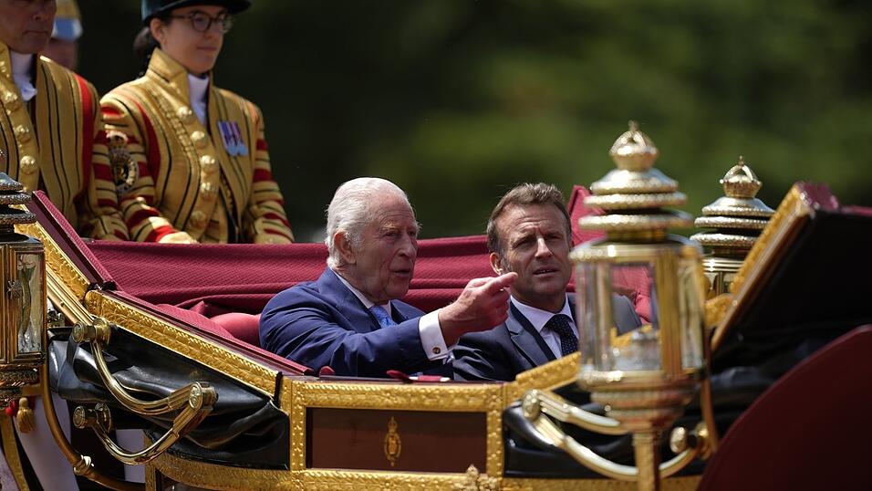 Der britische König Charles III. und Frankreichs Präsident Emmanuel Macron im Gespräch während der Kutschenprozession zum Schloss Windsor.