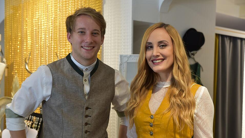 Das senfgelbe Dirndl trägt man beispielsweise in Kombi mit einer langärmeligen Spitzenbluse. Das Outfit in Lederhose & Co. ist farblich abgestimmt.