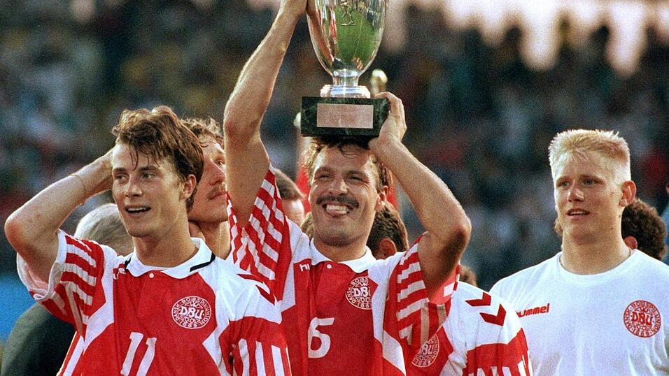 G&ouml;teborg, 26. Juni 1992 | Flankiert von St&uuml;rmer Brian Laudrup (l.) und Torh&uuml;ter Peter Schmeichel (r.) hebt Abwehrspieler Kim Christofte den eroberten EM-Pokal hoch. D&auml;nemark gewinnt vor 38.000 Zuschauern im Ullevi-Stadion sensationell gegen Weltmeister Deutschland mit 2:0.