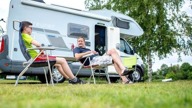 Zwei Camper sitzen vor ihrem Wohnmobil. Foto: Hauke-Christian Dittrich/dpa