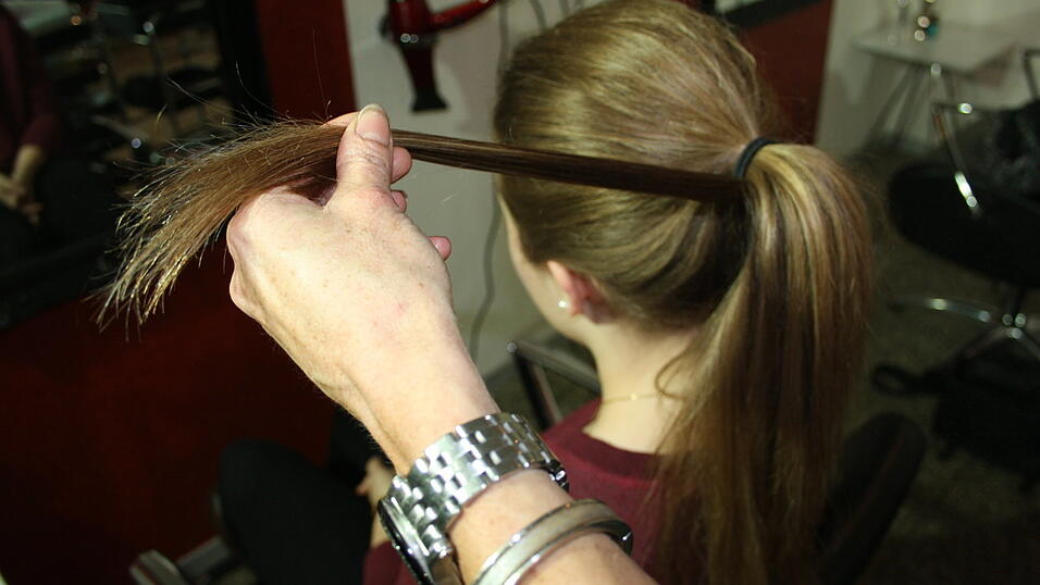 Schritt 3: Von unten eine Haarsträhne wegnehmen und damit den Gummi umwickeln, bis er nicht mehr zu sehen ist. Mit Haarnadeln feststecken. Schritt 3: Von unten eine Haarsträhne wegnehmen und damit den Gummi umwickeln, bis er nicht mehr zu sehen ist. Mit Haarnadeln feststecken.