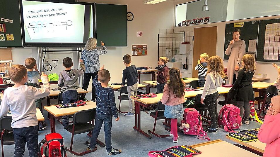 Sprachintensiver Unterricht in der ersten Klasse. Zusammen mit ihrer Klassenleitung Katharina Weber und Sonderpädagogin Lisa Flötner bilden die Kinder auditiv durch Reime und in motorischer Hinsicht durch Schwungübungen ihr Sprachgefühl aus. Sprachintensiver Unterricht in der ersten Klasse. Zusammen mit ihrer Klassenleitung Katharina Weber und Sonderpädagogin Lisa Flötner bilden die Kinder auditiv durch Reime und in motorischer Hinsicht durch Schwungübungen ihr Sprachgefühl aus.