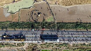 Ein Bagger hebt eine Grube aus, um den Kadaver eines Elefanten zu begraben, der bei der Kollision mit einem Zug ums Leben kam. Ein Bagger hebt eine Grube aus, um den Kadaver eines Elefanten zu begraben, der bei der Kollision mit einem Zug ums Leben kam.