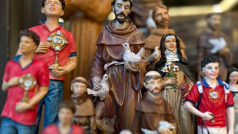 Figuren des alten und des neuen Heiligen stehen in Souvenirshops nebeneinander. (Archivbild)