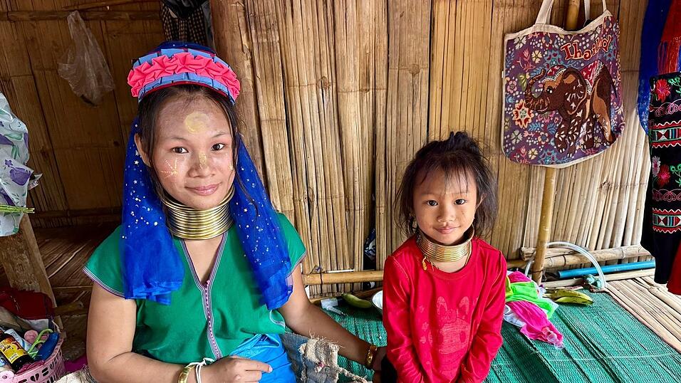 Die Langshalsfrauen und ihre Kinder sind daran gewöhnt, für Touristenfotos in die Kameras zu lächeln. Die Langshalsfrauen und ihre Kinder sind daran gewöhnt, für Touristenfotos in die Kameras zu lächeln.