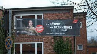 Kampagne der Beufsfeuerwehr Flensburg: Vergiss nie, hier arbeitet ein Mensch Vergiss nie, hier arbeitet ein Mensch steht auf dem großen Banner am Gebäude der Feuerwache in Flensburg. Mit einer gleichlautenden Kampagne will der Deutsche Gewerkschaftsbund (DGB) auf die steigende Zahl von Übergriffen auf Beschäftigte aufmerksam machen.
