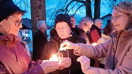 Das Osterlicht wird zu den Gl&auml;ubigen gebracht.
