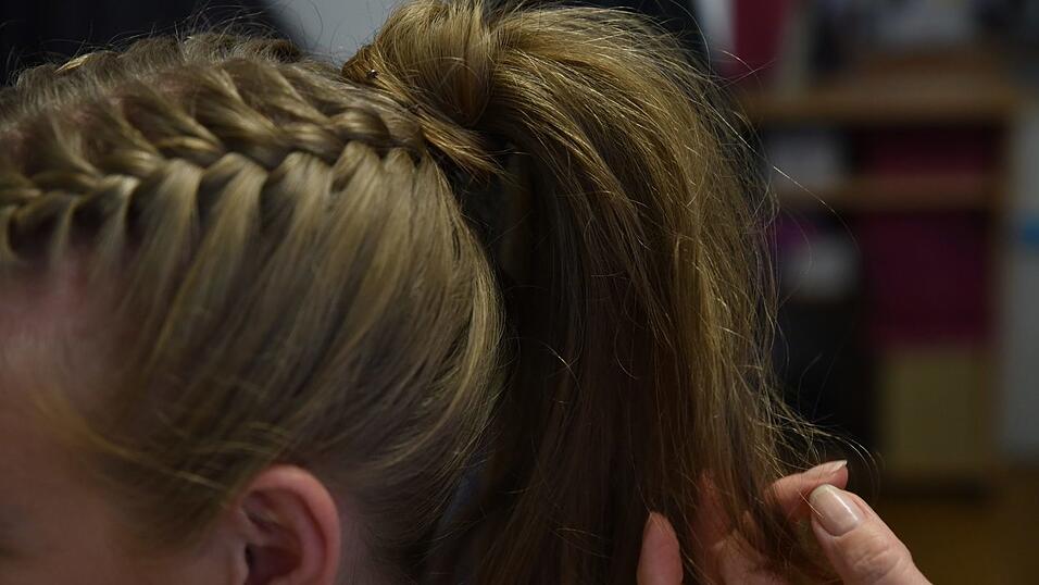 Abschließend den Pferdeschwanz in einen Dutt verwandeln und befestigen. Abschließend den Pferdeschwanz in einen Dutt verwandeln und befestigen.