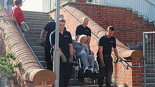 In Viererteams helfen Ehrenamtliche der Feuerwehr Vilsbiburg, die Teilnehmer der Wallfahrt hinauf und hinunter zu tragen