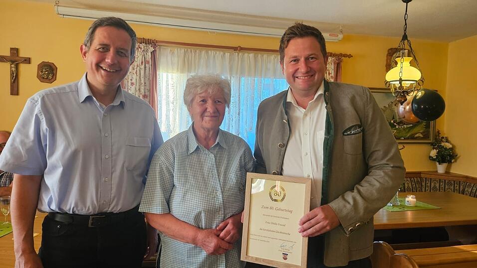 Pfarrvikar Anton Kopp (l.) und Bürgermeister Andreas Eckl überbrachten Glückwünsche zum 80. Geburtstag von Ottilie Freund.