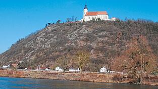 Majest&auml;tisch thront die Wallfahrtskirche auf dem steil abfallenden Bogenberg. Zu ihren F&uuml;&szlig;en, direkt am Flussufer, steht leicht links eine schwarze Tafel mit wei&szlig;en Zahlen. Diese zeigen an, dass die Donau auf ihrem Weg zum Schwarzen Meer ab diesem Punkt noch 2.310 Kilometer vor sich hat. Die Kilometertafeln geben der Schifffahrt Orientierung. An der Donau wird von der M&uuml;ndung aus flussaufw&auml;rts gez&auml;hlt.