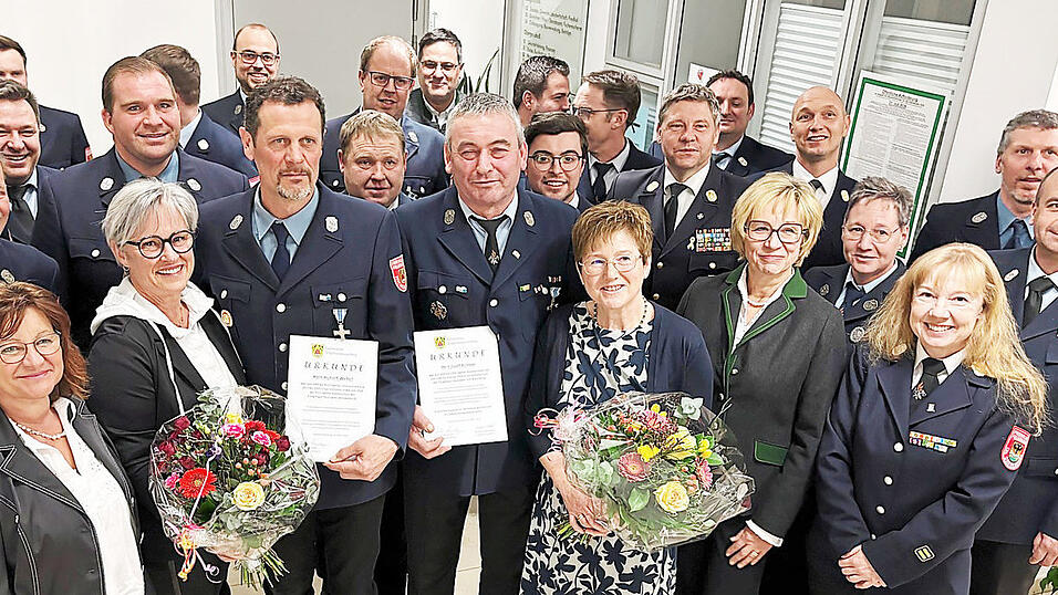 Die beiden Geehrten mit ihren Urkunden stehen umringt von vielen Gratulanten. Josef Krinner mit Frau Marianne von der Freiwilligen Feuerwehr Loh-Wischlburg (r.), daneben Hubert Weber mit Frau Sibylle (l.). Kreisbrandmeister Matthias Achatz und Kreisbrandinspektor J&uuml;rgen Kainz (hinten, v.r.) gratulierten genauso, wie Kreisbrandmeisterin Sandra P&ouml;schl und B&uuml;rgermeisterin Jutta Staudinger (vorne, v.r.).