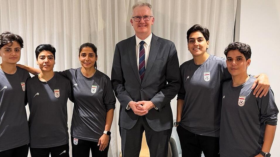Australiens Innenminister Tony Burke (M) mit Spielerinnen des Irans.