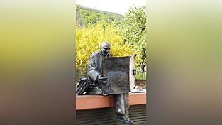 Vertieft in seine Lektüre, sitzt „Der Zeitungsleser“ entspannt auf seiner Bank: Die Bronzestatue des 2017 verstorbenen Künstlers Franz-Werner Müller-Steinfurth in Neustadt an der Weinstraße soll den Betrachter nach Aussage des Künstlers in der Hektik der Zeit zum Nachdenken anregen.