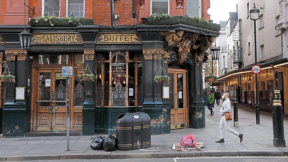Mit Atemmaske am geschlossenen Pub vorbei: Auch Gro&szlig;britannien schaltet im Kampf gegen die Corona-Pandemie einen Gang hoch. Das Problem: Das Gesundheitssystem ist geschw&auml;cht - auch wegen des Brexits.