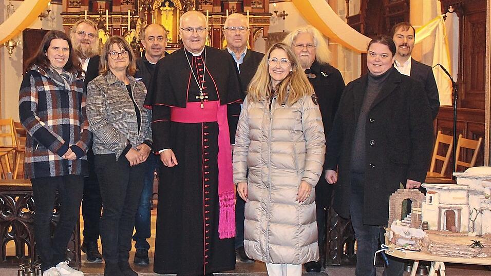 Bischof Rudolf Voderholzer mit den Vertretern der Pfarrei und Bürgermeisterin Sibylle Entwistle (7. von links). Rechts im Vordergrund ist die Krippe, die von Sabine Kohler (2. von links) an den Bischof überreicht wurde. Bischof Rudolf Voderholzer mit den Vertretern der Pfarrei und Bürgermeisterin Sibylle Entwistle (7. von links). Rechts im Vordergrund ist die Krippe, die von Sabine Kohler (2. von links) an den Bischof überreicht wurde.
