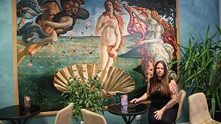 Bekannte Kunstwerke und K&uuml;nstler sind im Caf&eacute; &uuml;berall pr&auml;sent - nicht nur gro&szlig;fl&auml;chig an der Wand. F&uuml;r Kunst interessiert sich T&auml;towiererin Anna Doman &bdquo;schon immer&ldquo;, erz&auml;hlt sie.