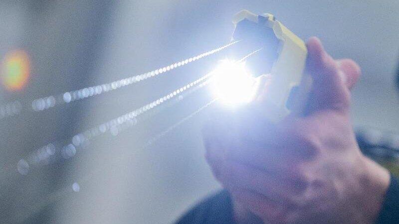 Ein Polizeibeamter demonstriert einen Schuss mit einem Taser.