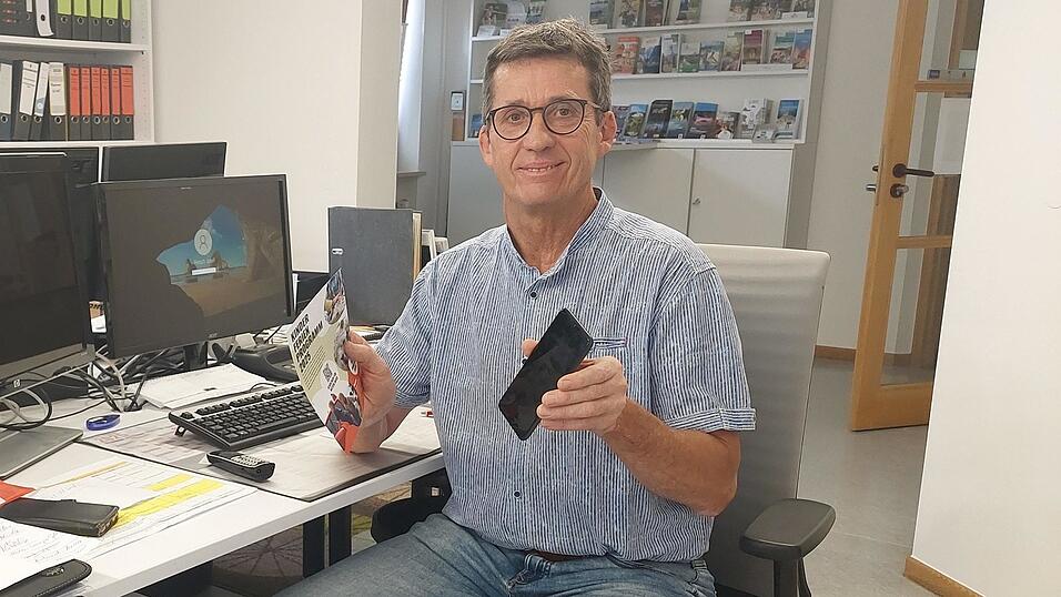 Josef Fersch zeigt, wie man via Smartphone und QR-Code zum Ferienprogramm kommt.