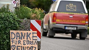 Ein Fahrzeug der Feuerwehr fährt an einem Schild mit der Aufschrift 'Danke für Euren Einsatz' beim Waldbrand im Hürtgenwald vorbei. Ein Fahrzeug der Feuerwehr fährt an einem Schild mit der Aufschrift 'Danke für Euren Einsatz' beim Waldbrand im Hürtgenwald vorbei.