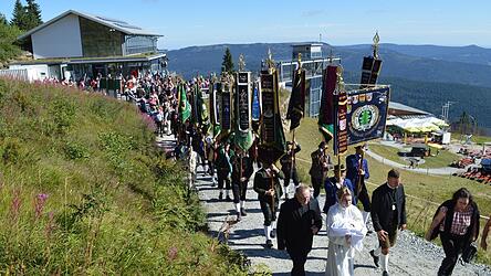 Die Vereine ziehen betend mit ihren Fahnen zum Arber.