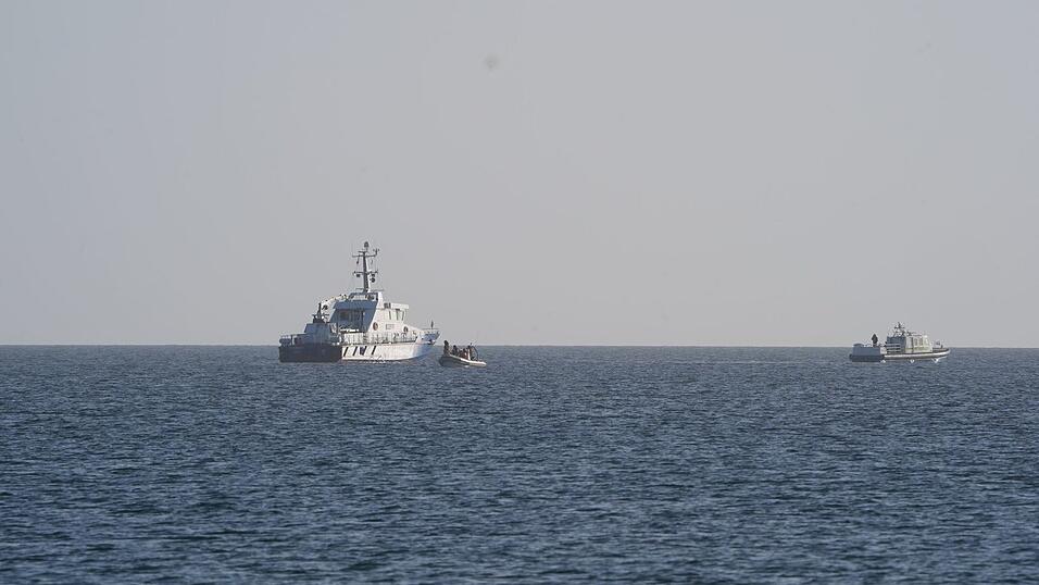 Der Buckelwal wird von mehreren Schiffen begleitet.