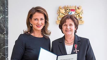 Christine Wutz und Staatsministerin Kaniber bei der Aushändigung der Verleihungsurkunde für das Verdienstkreuz am Bande