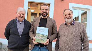 Helmut K&ouml;ppl (v.r.), B&uuml;rgermeister Johannes Brunner und Josef Zachmeier pr&auml;sentieren die 442 Seiten starke Chronik der Ortschaft Hausen.