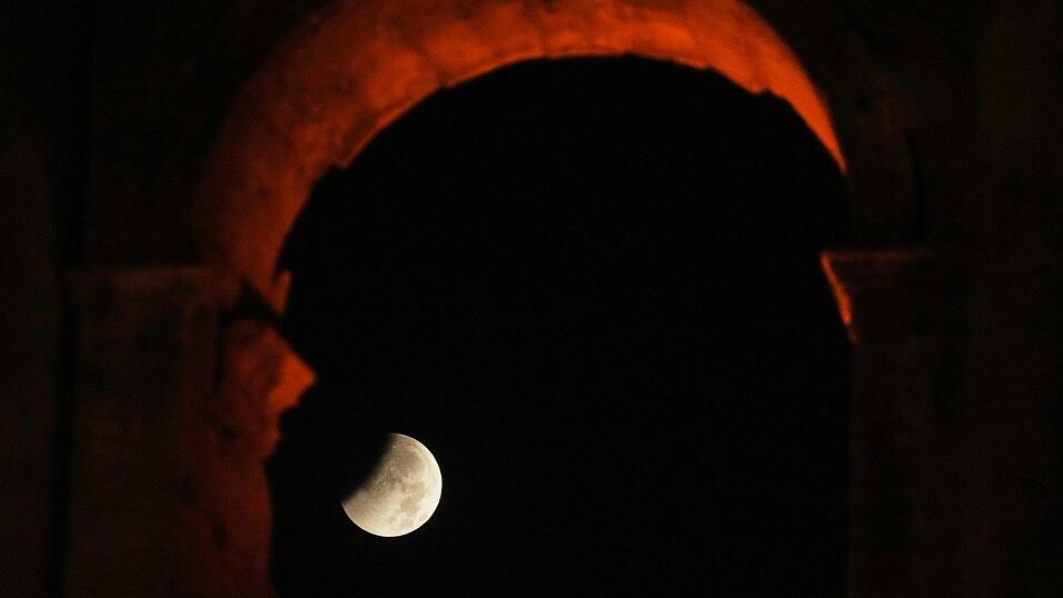 In Rom ging der Mond während der partiellen Finsternis hinter dem Kolosseum unter. In Rom ging der Mond während der partiellen Finsternis hinter dem Kolosseum unter.