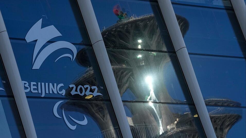 Der Pekinger Olympiaturm spiegelt sich in den Fenstern des Main Media Centers mit dem Logo der Winter-Paralympics 2022.